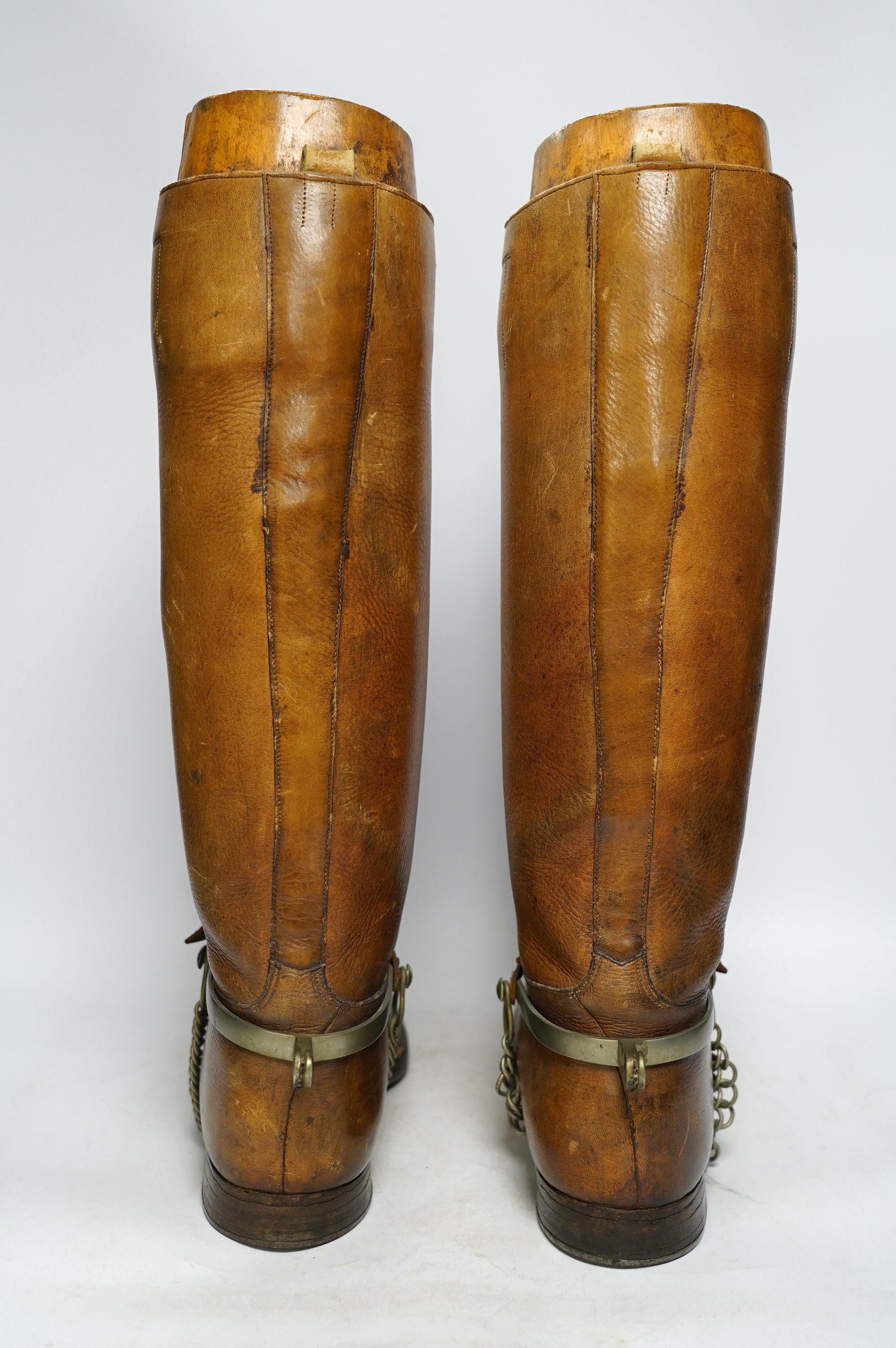 A pair of military First World War boots in tan leather, hobnail soles, two-part wooden shoe trees, and spurs. Condition - fair to good, some rubbing, fading and staining to the leather